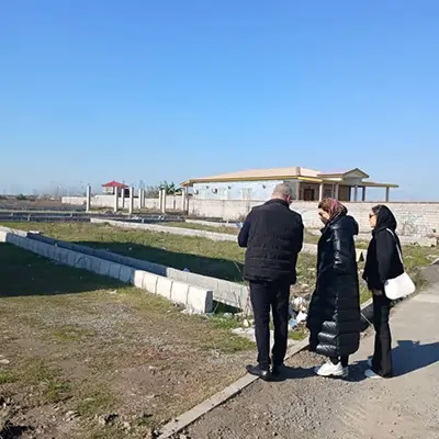 تصویر سه شخص در حال بررسی زمین در شمال